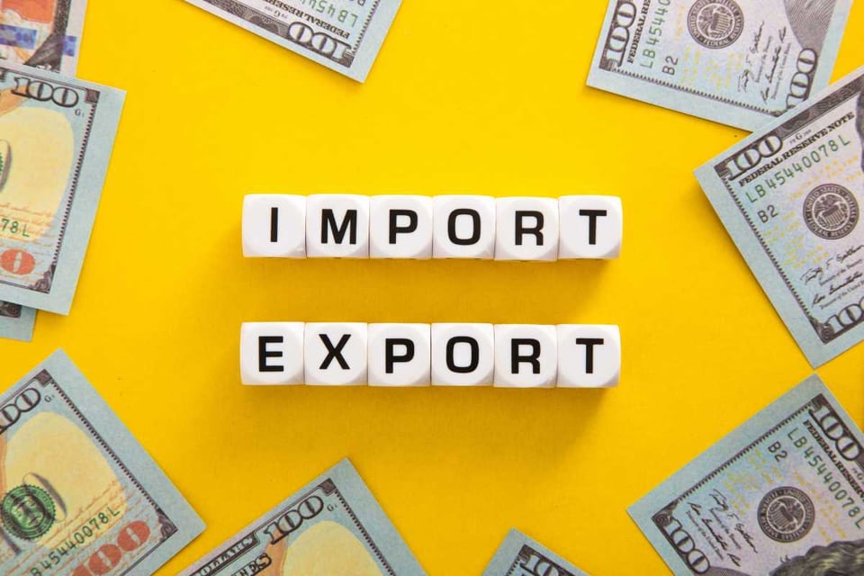 billetes en una mesa, palabras importación y exportación, costos de importación