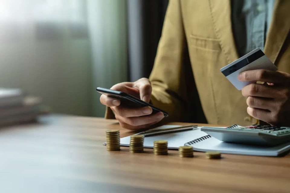persona con tarjeta de crédito en la mano y teléfono