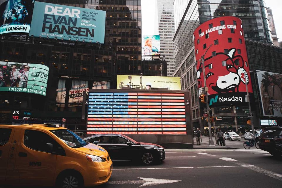 calle de nueva york con pantalla del Nasdaq