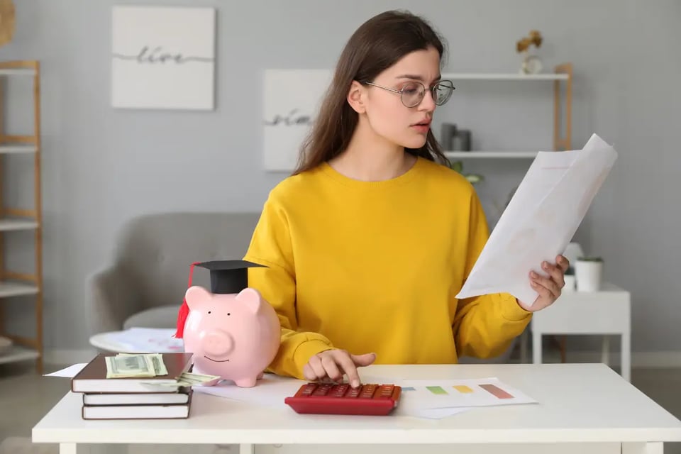 mujer revisando documento, préstamos estudiantiles
