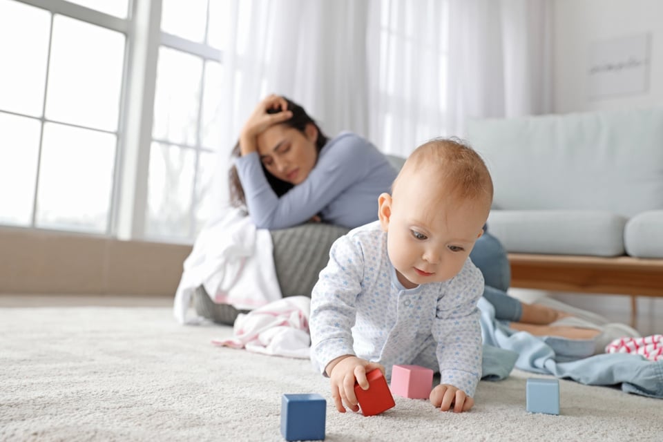 Pill approved for postpartum depression, baby playing, tired woman, MundoNow