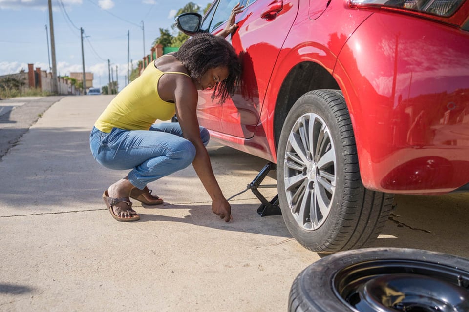 How to change a tire, black woman, car