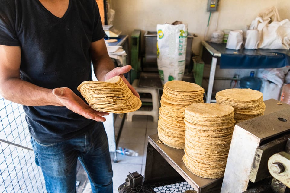 man making corn tortillas