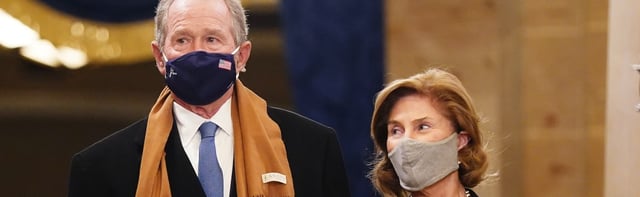 Former President George Bush appears with his wife carrying a mysterious baby
