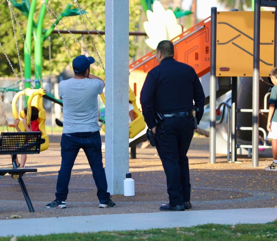 Foto de un policía charlando con un hombre en un parque