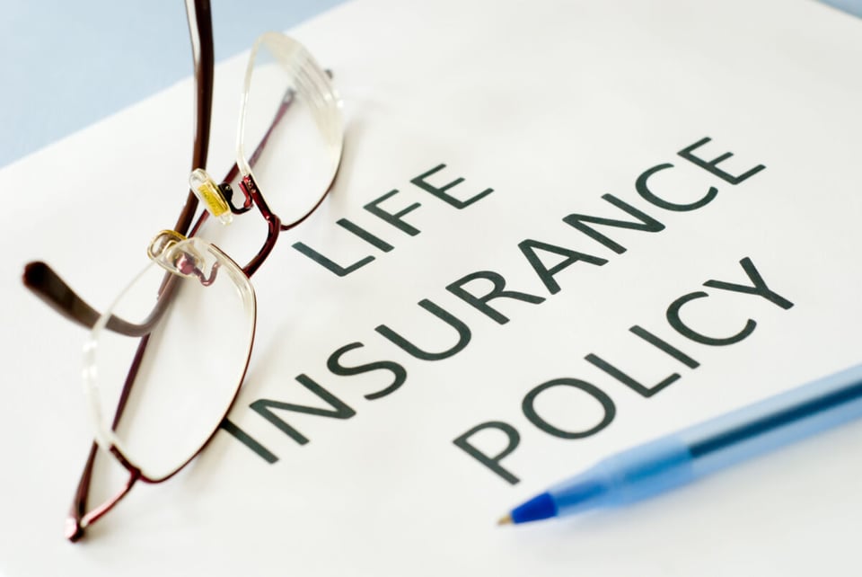 A Life Insurance Policy with glasses on top of it