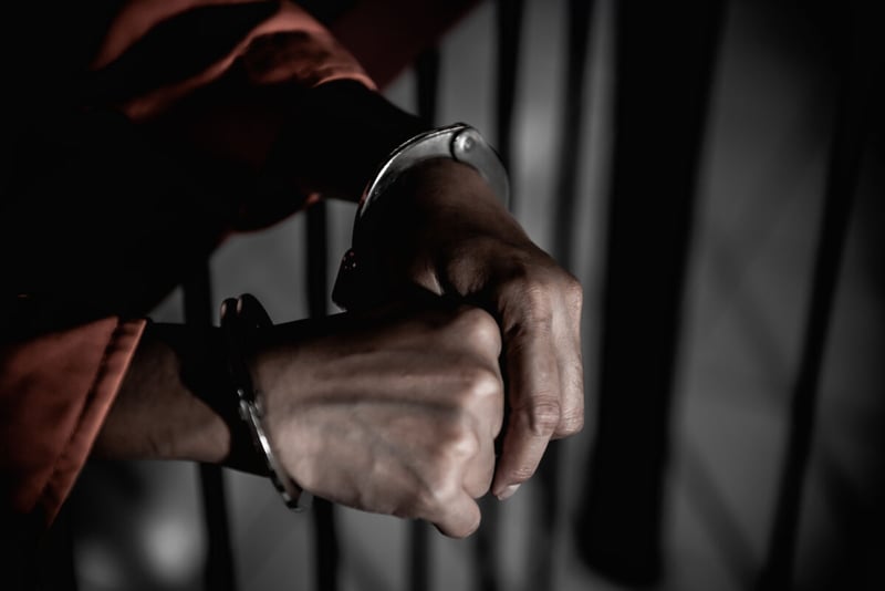 Hands of man in jail with handcuffs
