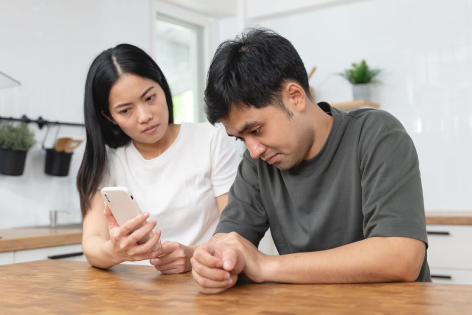 A woman with a man that is showing message of a cheater