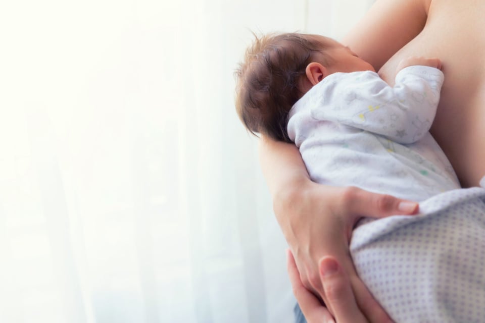 Mujer con bebé que está tomando pecho