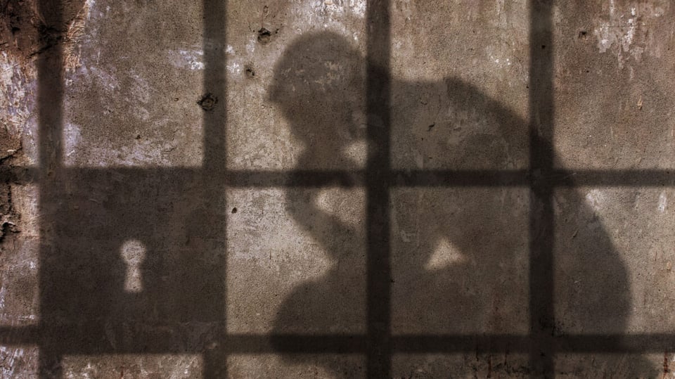 A shadow of a man in jail after sentence for murders