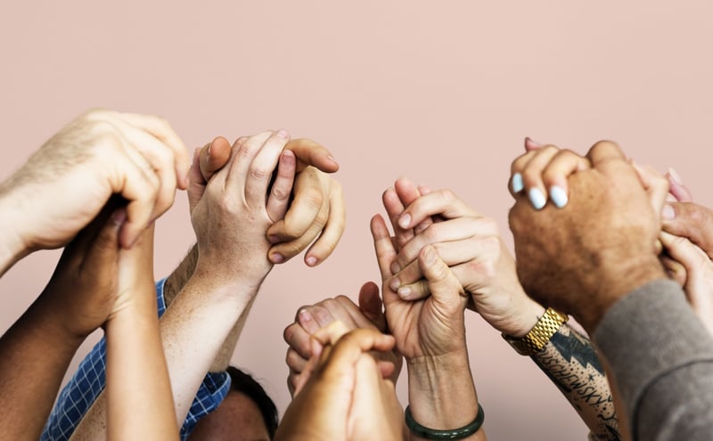 People with hands hold with the same goal