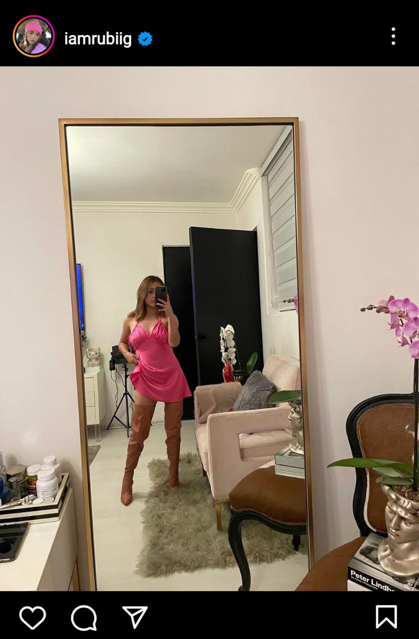 The ex-quinceañera Rubí wears long boots in front of the mirror