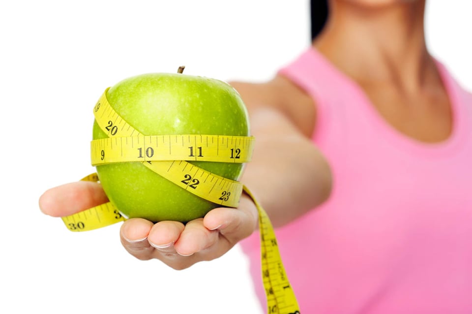 Beneficios para la salud de las manzanas, cinta métrica, mujer hispana, peso, dieta