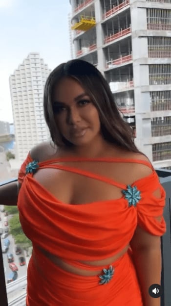 He moves his butt from side to side; appears twerking in an orange dress and is attacked