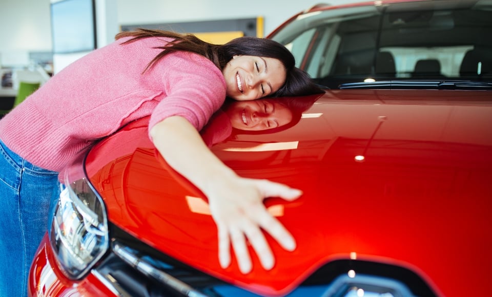 mujer abrazando carro, concesionaria, lote de autos, Motor, MundoNOW