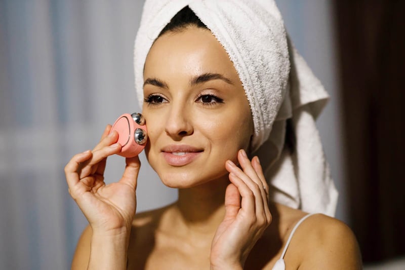 woman, towel on head using, microcurrent, facial, device