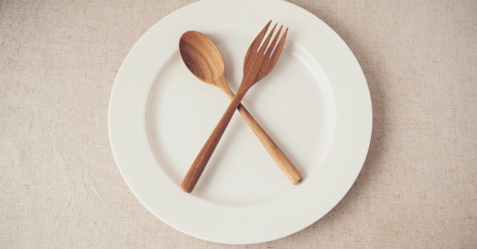 Unos cubiertos encima de un plato vacío