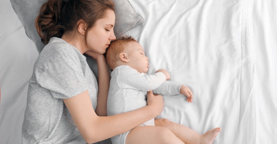 Bebé durmiendo junto con mujer