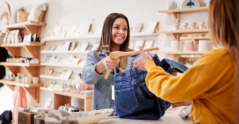A girl paying a person who has a job in a store