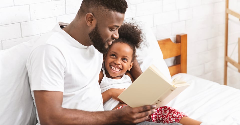 hombre con niña leyendo un libro