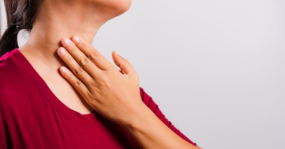 Mujer con dolor de garganta como uno de los síntomas de dolor