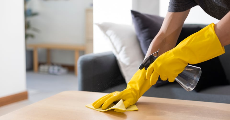 Persona limpiando la mesa de una casa