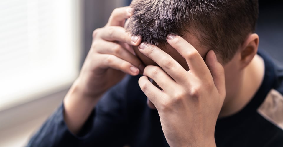 Joven con manos en el rostro por ansiedad