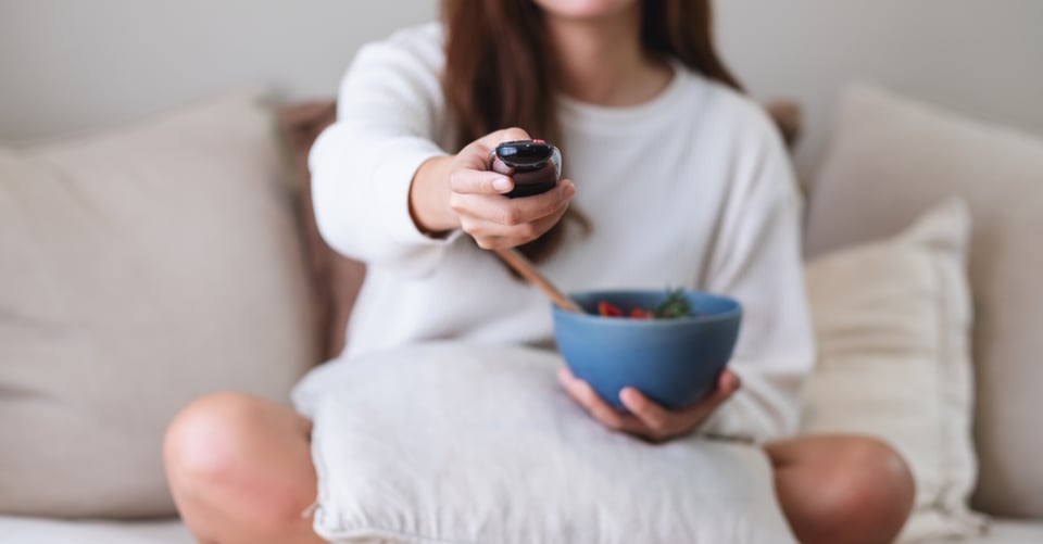 Chica en sofá viendo estrenos en televisión