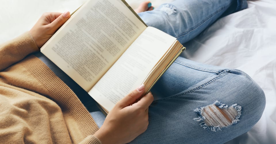 Persona en cama con libro en sus manos