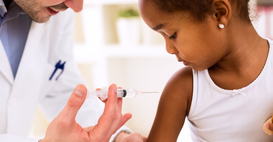 Pequeña en proceso de vacunación con médico
