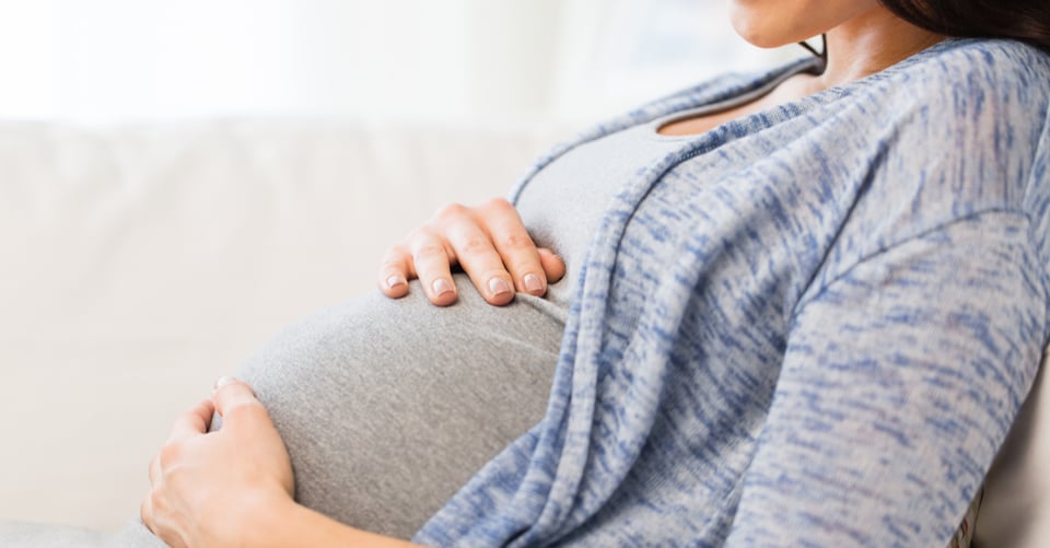 Image of a pregnant woman grabbing her belly