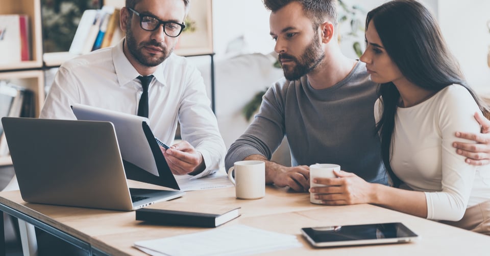 A couple discussing the purchase of a first home with an executive
