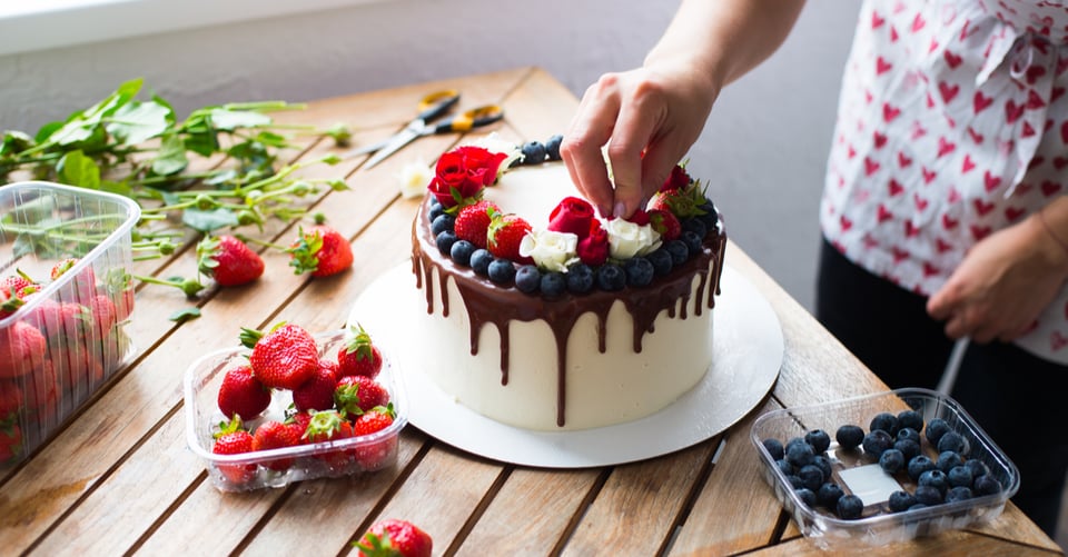 A person decorating a cake