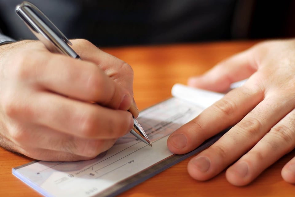 Man, writing a check, money, finance, MundoNOW