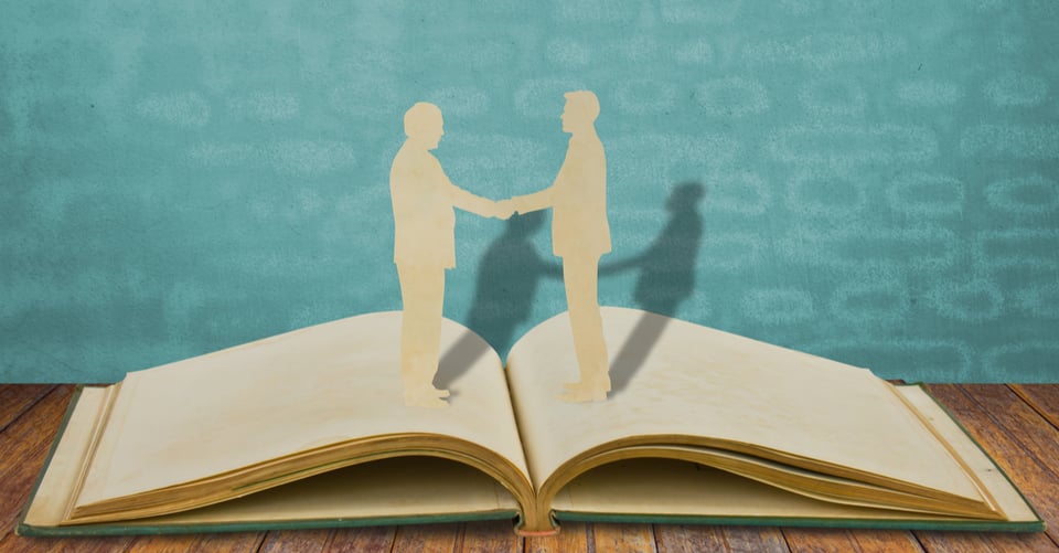 Dos empresarios de papel en un libro abierto