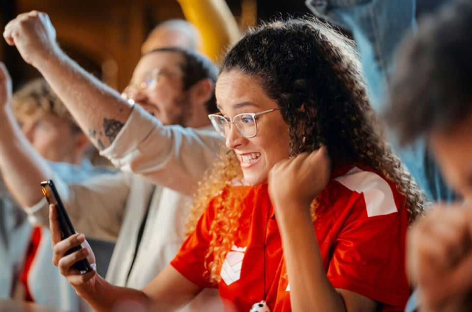 Portrait of an Anxious Multiethnic Female in Red Jersey, smartphone,