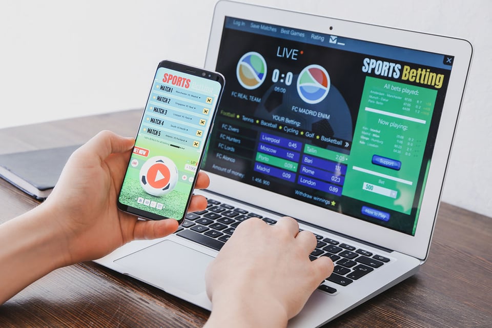 Man placing sports bet at home, computer, Sports betting tips