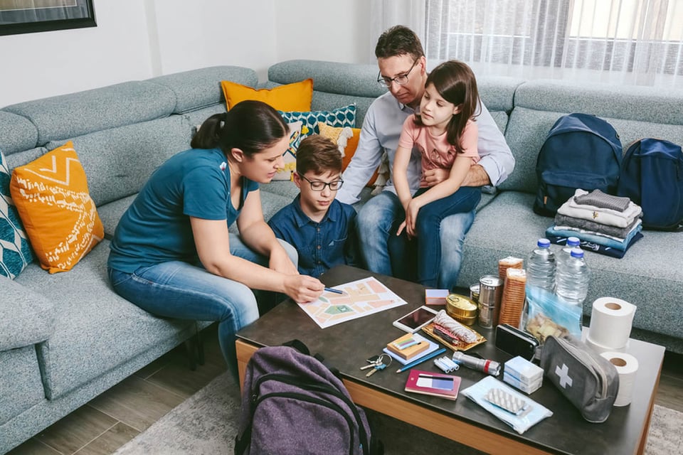 Madre y su familia, preparando kit de emergencia, sala, suministros, familia