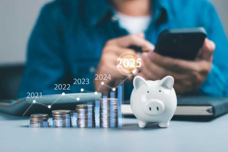 persona con teléfono en una mesa con monedas, ahorro para jubilación