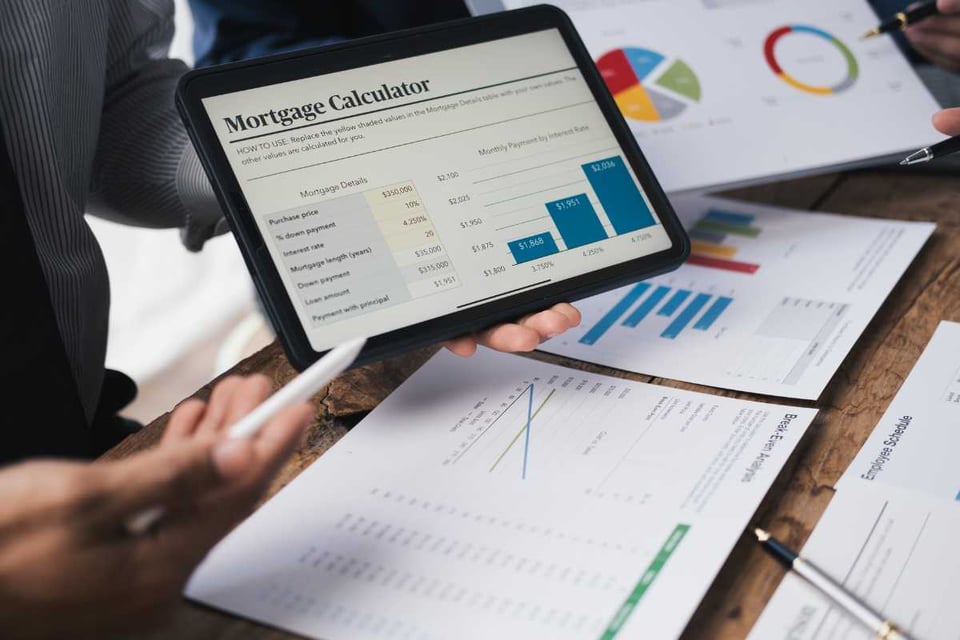 persona muestra el calculo de credito hipotecario en tableta
