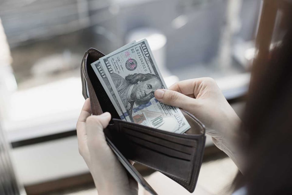 persona conmtando billetes en una billetera