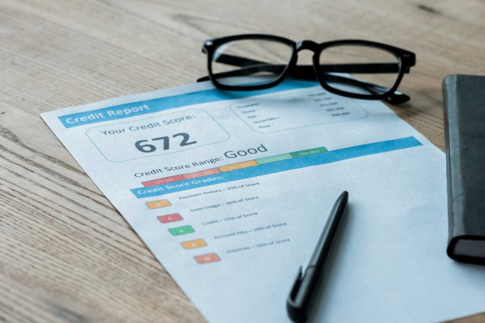 reporte con datos de credito en una mesa con lentes y boliografo