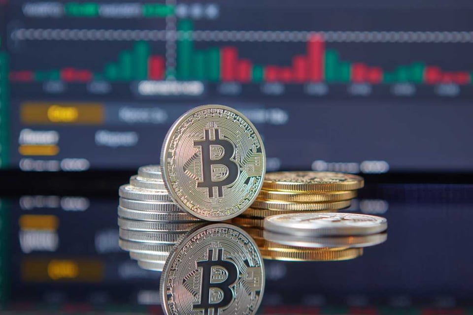 monedas doradas frente a un monitor con barras de colores