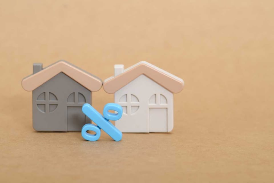 figura de casas y simbolo de porcentaje, tasas de interes hipotecario