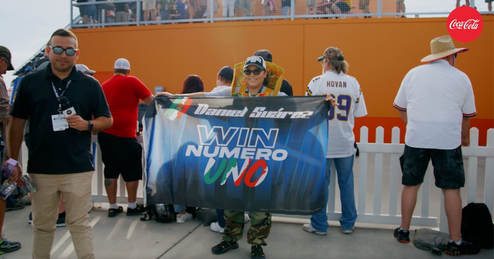 A woman with a fabric that says Daniel Suárez Win Numero Uno