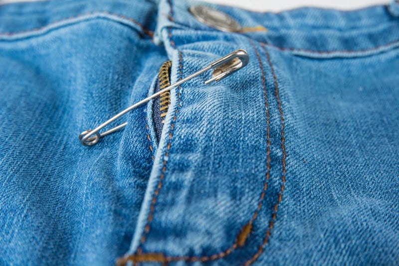 Broken blue jeans zipper, safety pin