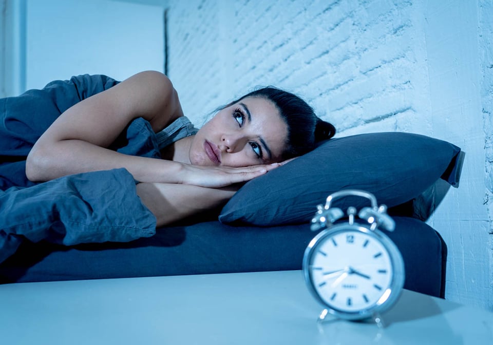 hispanic woman lying in bed, trying to sleep, alarm clock, insomnia 