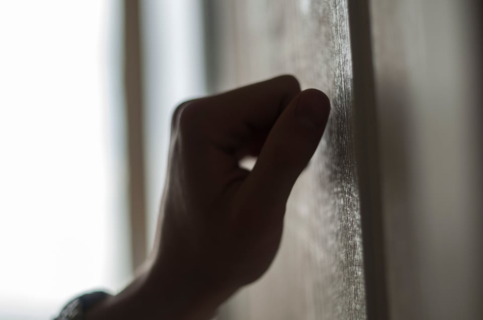 A hand knocking on a kids door