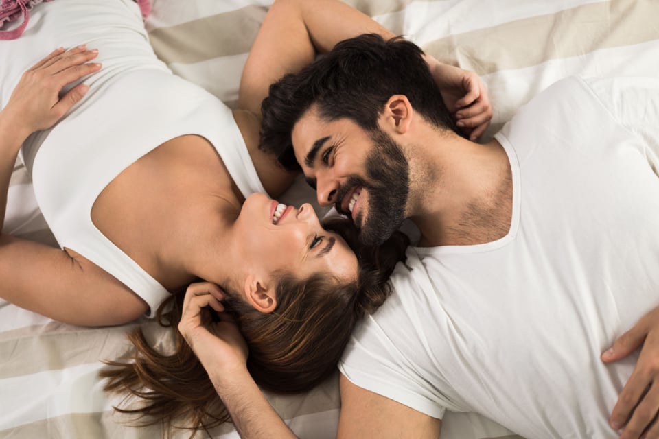 Couple in bed smiling