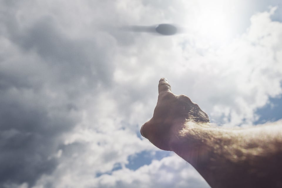 UFO in the sky being pointed by a person's finger